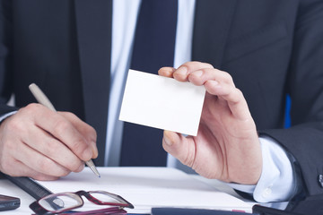 businessman with business card in foreground