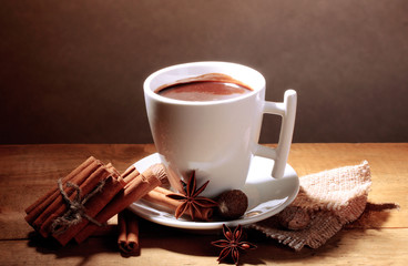 cup of hot chocolate, cinnamon sticks, nuts and chocolate