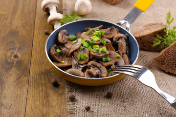 Delicious fried mushrooms in pan on table close-up