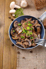 Delicious fried mushrooms in pan on table close-up