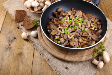 Delicious fried mushrooms in pan on table close-up
