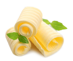 Curls of fresh butter with basil, isolated on white