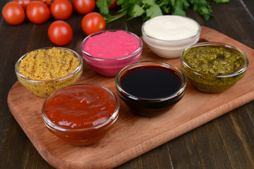 Various sauces on chopping board on table close-up