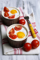 Baked eggs on wooden table close up