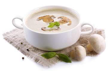 Mushroom soup in white bowl, on napkin, isolated on white