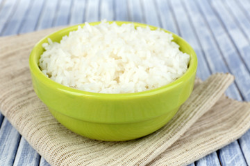 Cooked rice in bowl on wooden background