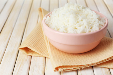 Cooked rice in bowl on wooden background