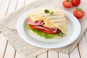 Tasty sandwich with ham on wooden table