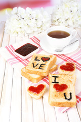 Delicious toast with jam and cup of tea on table close-up