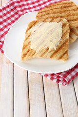 Grilled bread with butter on wooden table