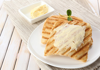 Grilled bread with butter on wooden table