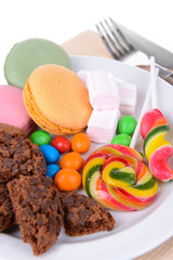 Different sweets on plate on table close-up