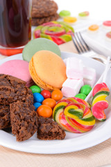 Different sweets on plate on table close-up