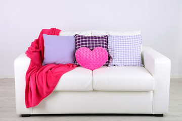 Pink heart shaped pillows, plaid on white sofa