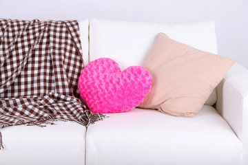 Pink heart shaped pillows on white sofa
