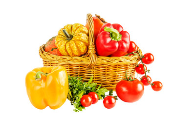 Still life with vegetables in a wicker basket on a white backgro