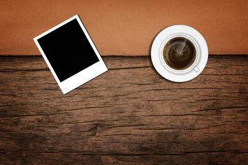 Fototapeta na wymiar coffee with polaroid photo frame on wood background