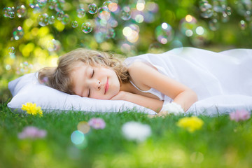 Kid sleeping in spring garden