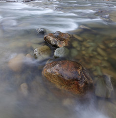 Fototapeta na wymiar Długa ekspozycja strzał z rzeki z kamieniami