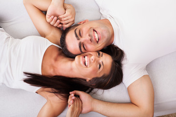 Romantic young couple Lying Down in bed.
