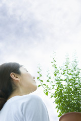 Woman holding Calamintha and sky