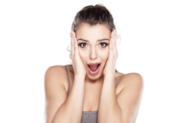 Young shocked woman on white background