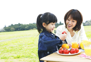 mother and daughter enjoying picnic in prairie