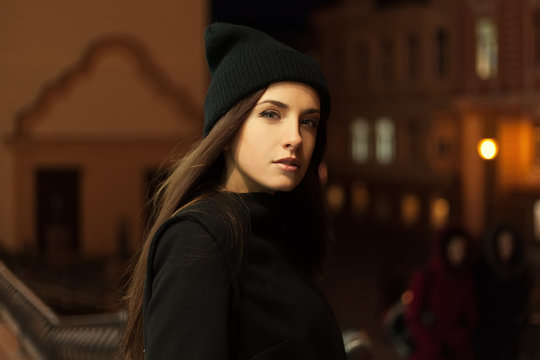 Beautiful girl in the evening in hat and coat