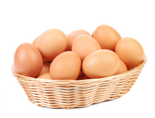 Brown eggs in the basket on a white.