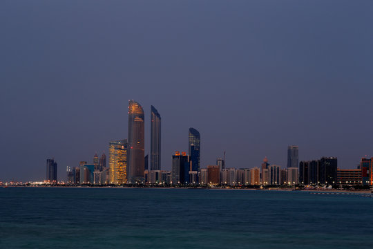 A skyline view of the Corniche Road in Abu Dhabi, UAE at dusk