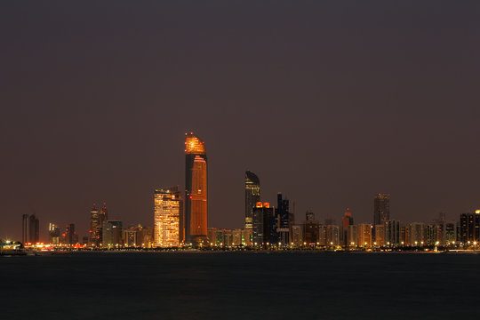 A skyline view of the Corniche Road in Abu Dhabi, UAE at dusk