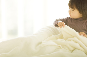 Japanese child trying to get into bedclothes