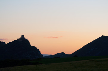 silhouette of a castle on a hill, at sunset
