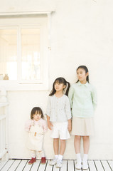 Fototapeta na wymiar Three Japanese girls standing by the wall