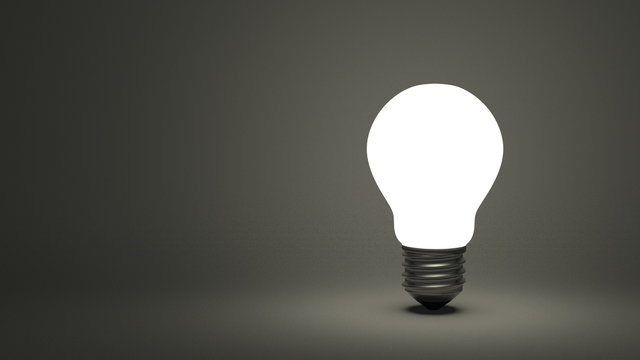 Glowing light bulb on gray