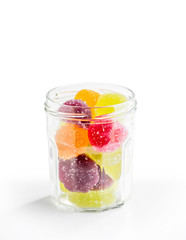 Fototapeta na wymiar Colorful fruit jelly in open glass jar, on white background