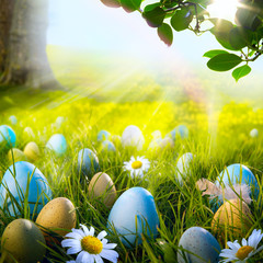 Art decorated easter eggs in the grass with daisies