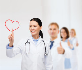 smiling female doctor pointing to heart