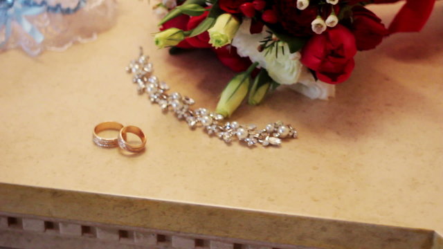 bridal bouquet and gold rings on the table