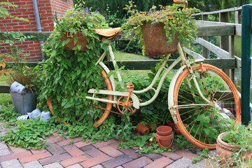 Fototapeta na wymiar Stary rower ze śmieciami do dekoracji w ogrodzie