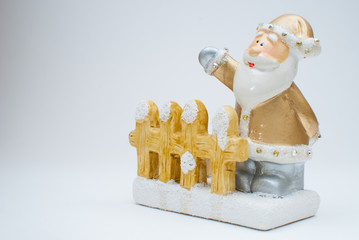 Golden old time Santa Claus figurine behind garden fence