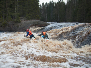 Two men sitting on a catamaran on the background of the river
