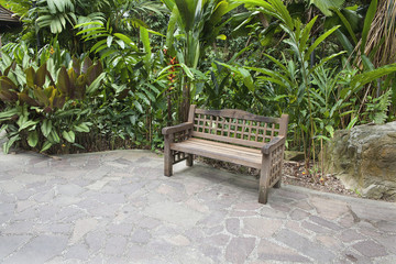 Naklejka premium Wood Bench in Tropical Garden