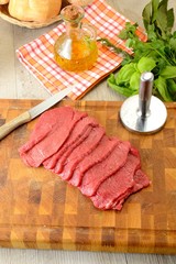 Fettine di carne di manzo crude sul tagliere di legno