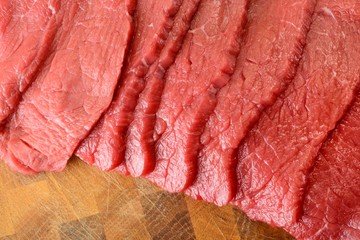 Fettine di carne di manzo crude sul tagliere di legno