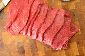Fettine di carne di manzo crude sul tagliere di legno