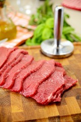 Fettine di carne di manzo crude sul tagliere di legno
