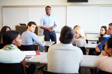 Obraz premium Male Tutor Teaching University Students In Classroom