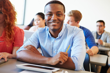 Male University Student Using Digital Tablet In Classroom