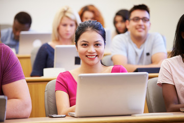 Fototapeta premium Female University Student Using Laptop In Lecture
